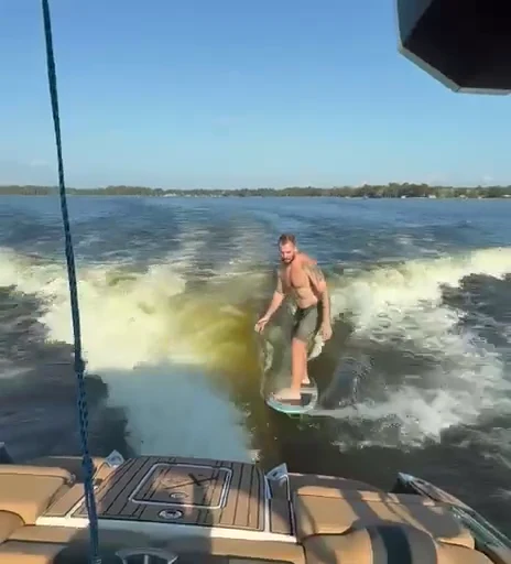 A wakesurfer riding the wave behind the boat